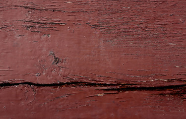 A dull red wooden surface with a crack. Old dull red wooden surface