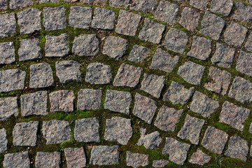 The medieval road. Old road made of square stones. Square stones in the ground