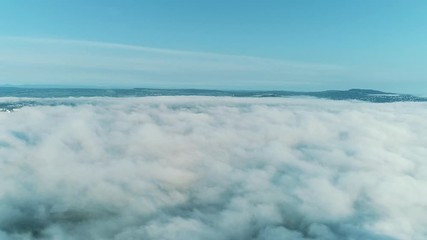 4k timelapse low angle view cloudscape with wind blowing white fluffy clouds passing the sun in clear sky with sunlight through the cloud.