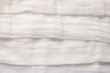 white color woven cotton gauze fabric background texture. close up top view. Selective soft focus. Shallow depth of field. Text copy space.