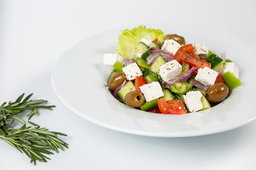 Greek salad on a plate on a white background