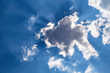 clouds in blue sky with rays of sun
