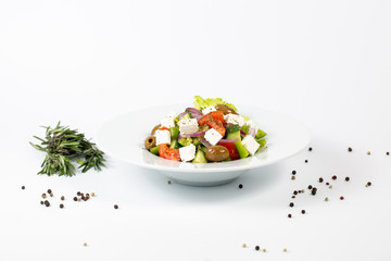 Greek salad on a plate on a white background