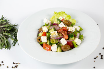 Greek salad on a plate on a white background