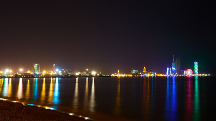 Fototapeta na wymiar Night reflections of lights in Black Sea port of Batumi, capital of Adjara. Georgia.