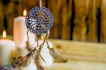 Dreamcatcher amulet feng shui. Dream catcher from metal and farts against the background of burning...