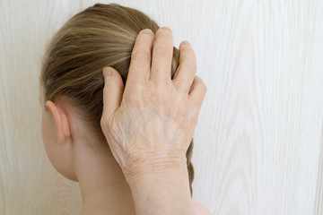 elderly woman stroking a girl's head