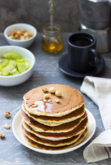 Vegetarian breakfast of pancakes, coffee, honey, nuts and fruits.