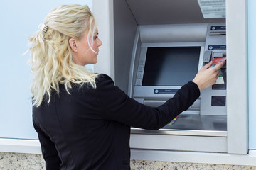 Businesswoman withdrawing money from credit card at ATM