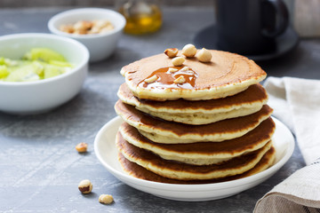 Vegetarian breakfast of pancakes, coffee, honey, nuts and fruits.