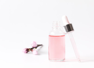 Fototapeta na wymiar Dropper Bottle with a pipette and pink water.Organic SPA cosmetics .Mock-Up.