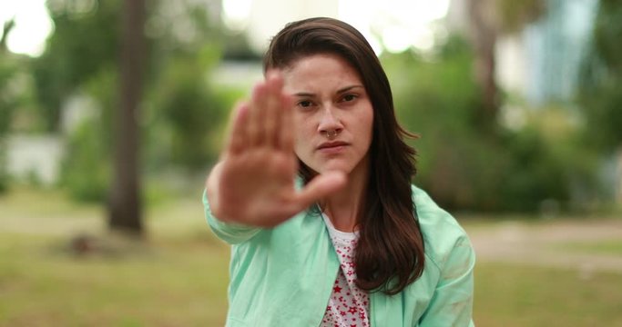 Woman expressing NO with her hand. Serious defensive millennial girl holding her hand in objection