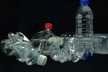 A color image of single use plastic bottles that need to be recycled.