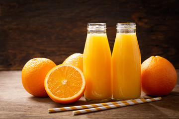 bottles of orange juice with fresh fruits