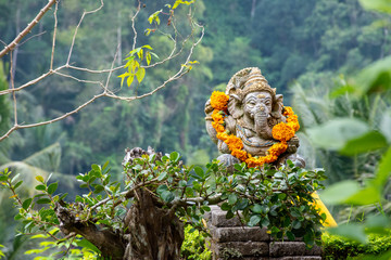 Statua di Ganesha a Bali con ghirlanda di fiori arancio al collo