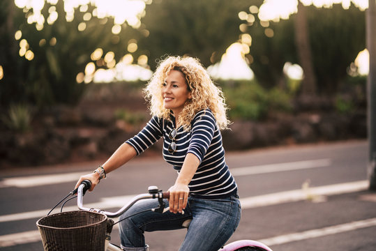 Beautiful And Cheerful Adult Young Woman Enjoy Bike Ride In Sunny Urban Outdoor Leisure Activity In The City - Happy People Portrait - Trendy Female Outside Having Fun