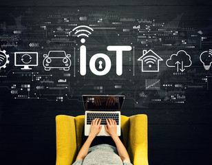 IoT theme with person using a laptop in a chair