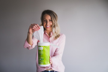 Young woman pulling a disinfectant wipe out from the container