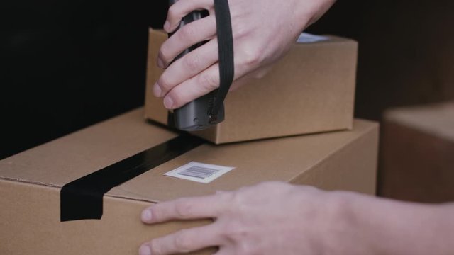 Delivery man scanning boxes with barcode scanner
