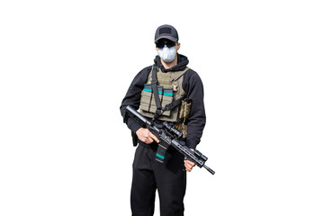 Obraz na płótnie Canvas Army Man wearing Tactical Uniform and holding Machine Gun in Hands and Aiming. Isolated on White Background. Black Clothes and Hoody. White Mask against Coronavirus, disease or virus