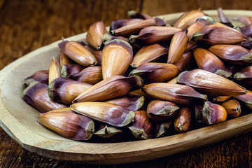 pine nut seed on rustic wooden table. Brazilian cuisine, consumed in winter and June parties.