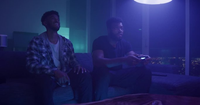 Freinds playing video games at night in apartment