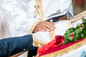 Obraz na płótnie Canvas Groom and bride holding hands on the bible