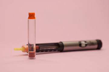 injector pen, insulin cartridge and injector on a pink background