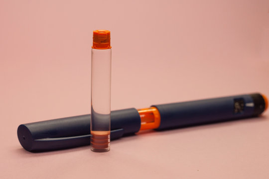 insulin cartridge and injector injector pen for diabetes on a pink background