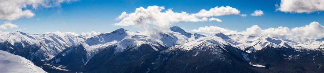 Fototapeta na wymiar Whistler, British Columbia, Canada. Beautiful Panoramic View of the Canadian Snow Covered Mountain Landscape during a cloudy and vibrant winter day. Nature Background Panorama
