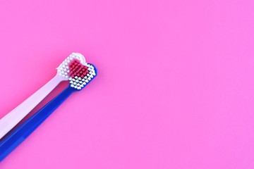 Two toothbrush for personal dental care on purple background. Romantic toothbrushes with red heart. St. Valentine's Day concept. Lovers toothbrushes. Personal hygiene 