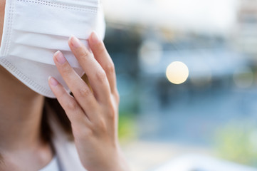 Crop image of young woman wearing surgical mask against Coronavirus spreading situation in public