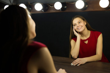 beautiful young woman near the mirror on black background