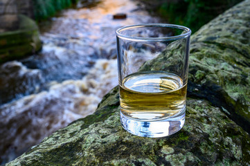 Scotch single malts or blended whisky spirits in glasses with water of river Spey on background, Scotland