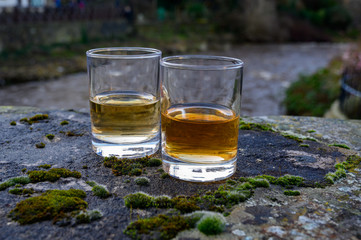 Scotch single malts or blended whisky spirits in glasses with old street in Edinburgh on background, Scotland