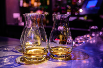 Obraz na płótnie Canvas Flight of Scottish whisky, tasting glasses with variety of single malts or blended whiskey spirits on distillery tour in pub in Scotland