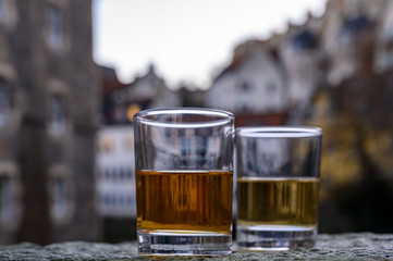 Scotch single malts or blended whisky spirits in glasses with old houses of Edinburgh on background, Scotland, UK