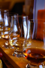 Flight of Scottish whisky, tasting glasses with variety of single malts or blended whiskey spirits on distillery tour in Scotland