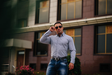 Young successful man near an office building. Business