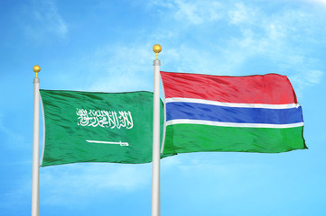 Saudi Arabia and Gambia two flags on flagpoles and blue cloudy sky