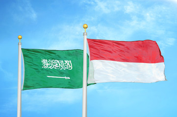 Saudi Arabia and Indonesia two flags on flagpoles and blue cloudy sky