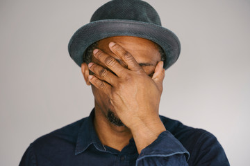 Young ethnic male trying to control his anguish and frustration trying not to cry. Anguish emotion....
