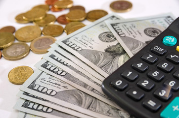 Fototapeta premium calculator, dollars and coins on white.