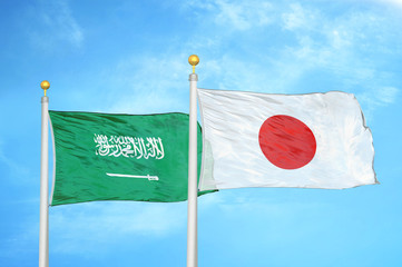 Saudi Arabia and Japan two flags on flagpoles and blue cloudy sky