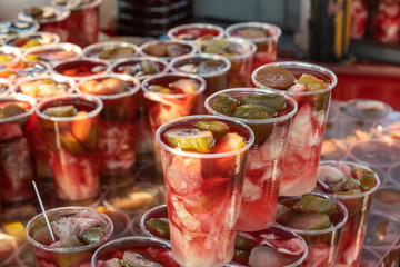 Pickled cucumber and cabbage slices with pickle juice in glass. Delicious and healthy street food.