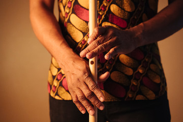 Detail of hands of African American man musician playing the flute with copy space. Online music class learning musical instruments. Rhythm and blues style. Ethnic culture and traditions.