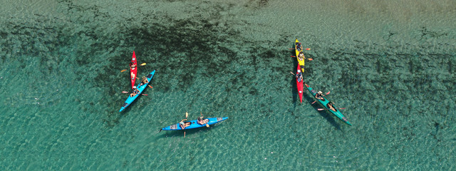 Aerial drone ultra wide photo of young athlete team practising sport canoe in tropical exotic bay...