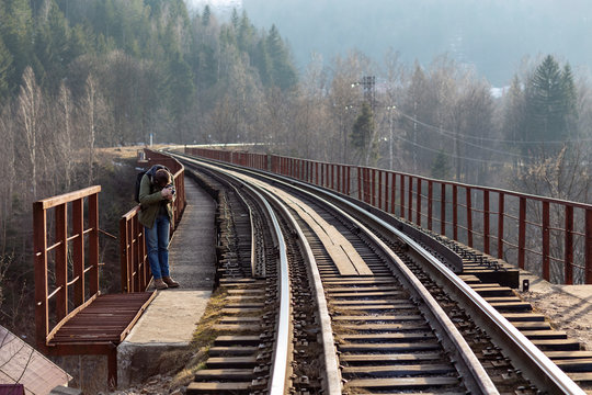 railroad rails across the bridge close up of a photographing man