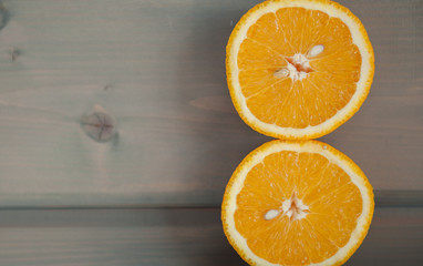 A bright juicy orange cut on a grey wooden background
