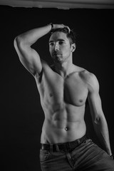 Obraz na płótnie Canvas black and white studio shoot of strong athletic man on dark background